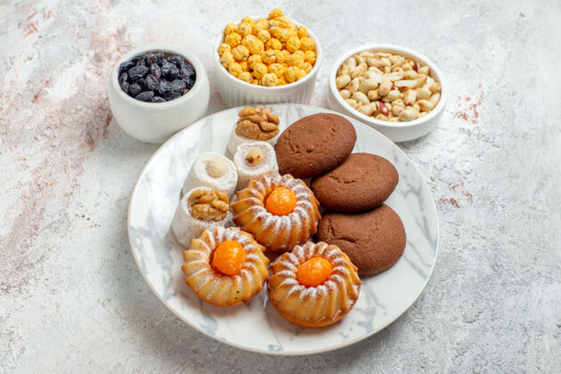 饼干前视图白色空间上有糖果和坚果的甜饼干糕点早餐糖果