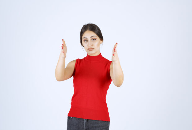 人穿红衬衫的女孩展示了一个物体的尺寸宽度女工人