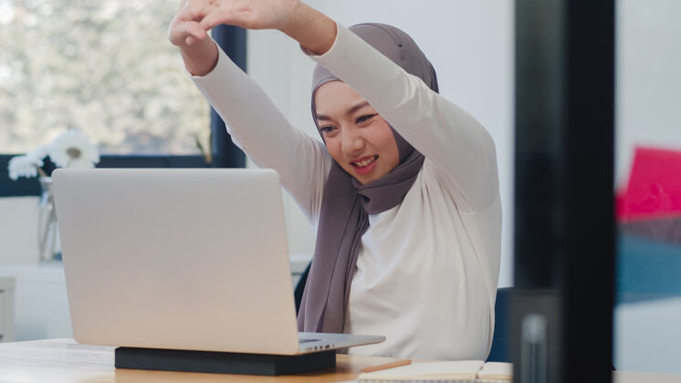 笔记本电脑美丽的亚洲女士休闲装 在现代新常态办公室使用笔记本电脑工作阿拉伯语商业技术