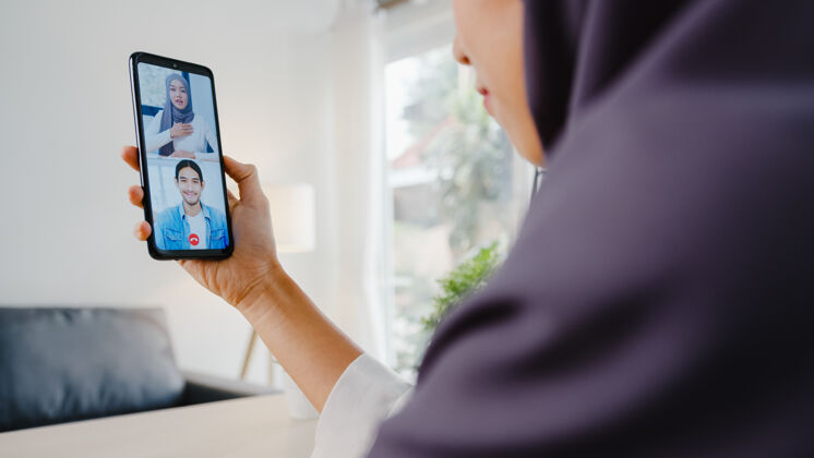 社交年轻的亚洲女商人用智能手机和同事视频聊天女性通信会议