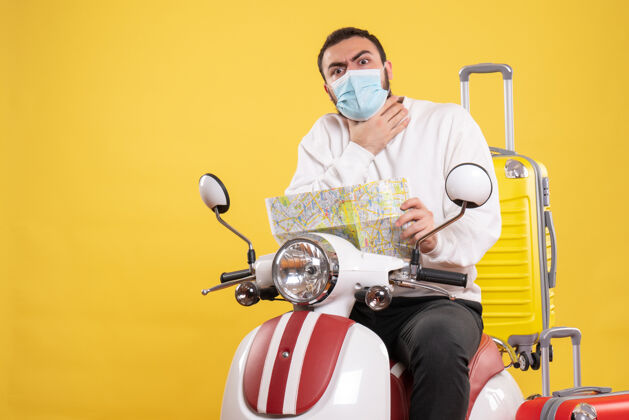 摩托车一个戴着医用面罩的紧张的家伙坐在摩托车上 背着黄色的手提箱 拿着地图 把自己闷死在黄色的车上人黄色医疗