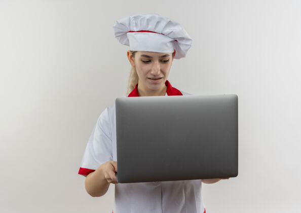 制服年轻漂亮的厨师穿着厨师制服拿着笔记本电脑 看着隔离在白色墙上的复印空间烹饪年轻厨师