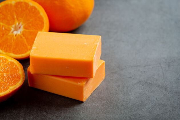 浴室橙色肥皂与新鲜的橙色在黑暗的背景清洁治疗香水