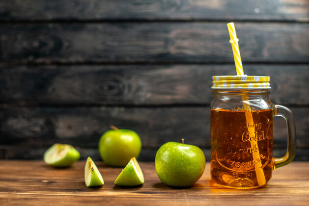 柑橘正面图新鲜苹果汁罐内有新鲜的绿色苹果 鸡尾酒上有深色水果饮料的照片颜色苹果鸡尾酒新鲜