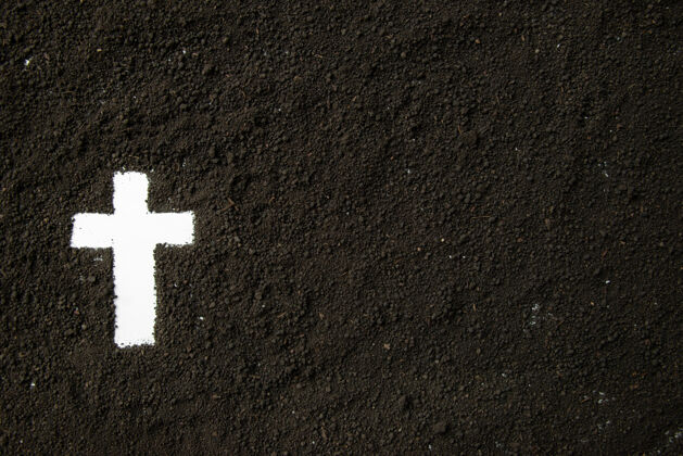 黑暗白色十字形和深色土壤的顶视图葬礼严峻灰色
