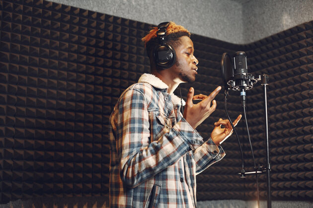 音频电台主持人在录音室录制播客时做手势非洲男人在录音室排练流行黑人声音
