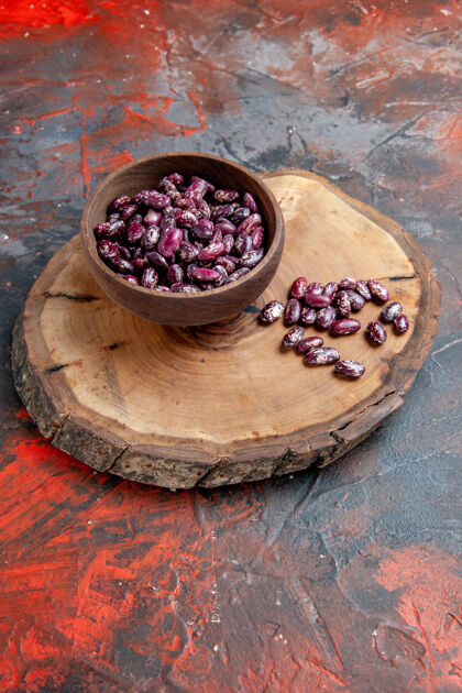 多汁即食锅的垂直视图黑色豆豆一个棕色的碗在一个木制托盘上的混合色背景农产品健康盘子