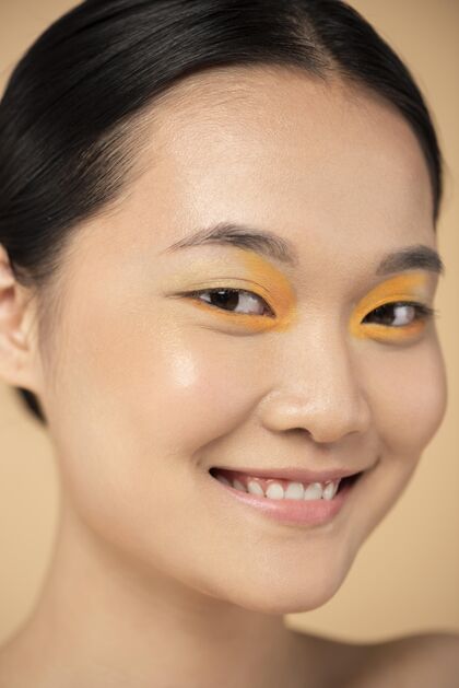 漂亮美丽的亚洲女人戴着橙色眼影魅力人积极