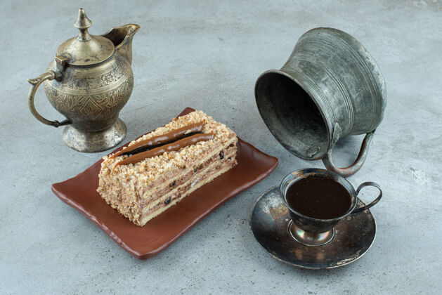 小块用一杯茶和茶杯在大理石表面切蛋糕糕点茶壶自制