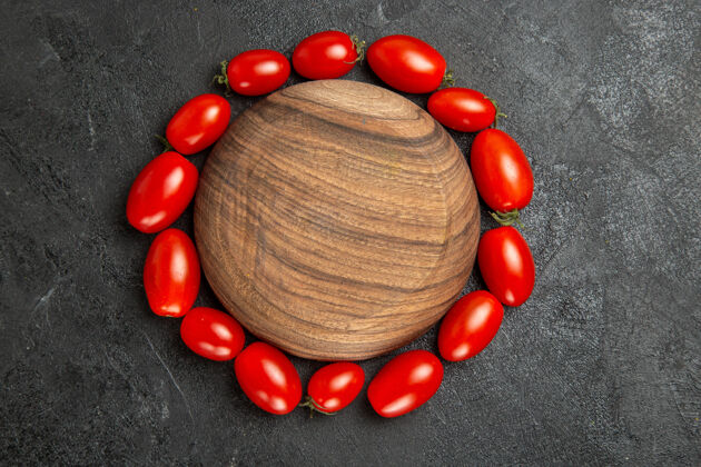 装饰顶视图樱桃西红柿围绕着一个黑暗的地面与复制空间木制板木头食物盘子
