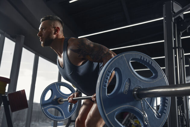 力量年輕肌肉運動員練習引體向上在健身房與杠鈴體重陽剛肌肉