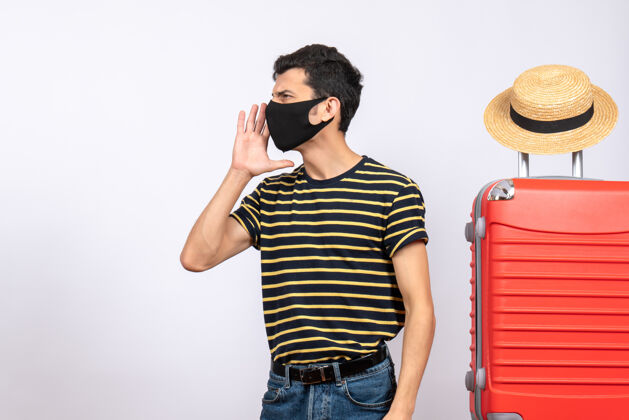 红正面图：戴着黑色面具的年轻游客站在红色手提箱旁呼唤着某人眼镜男黑