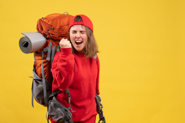 快递正面图：背着背包的年轻女旅行者表达她的幸福正面时尚背包