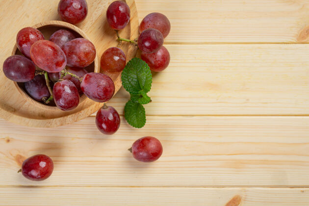 边界一束束新鲜成熟的红葡萄放在木头表面生长集群葡萄酒