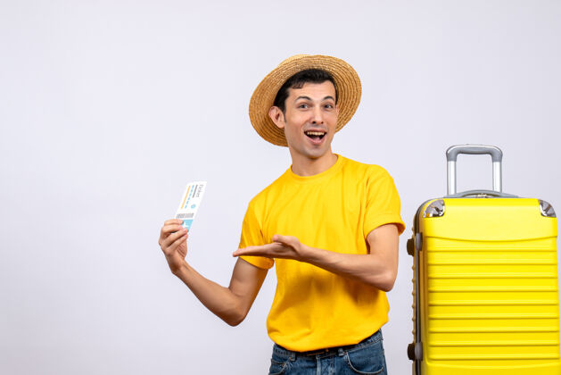 帽子正面图年轻游客手持机票站在黄色手提箱旁年轻游客视图站