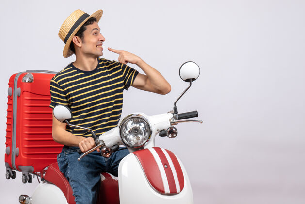 车辆一个戴着草帽的年轻人正对着他的微笑摩托车稻草视图