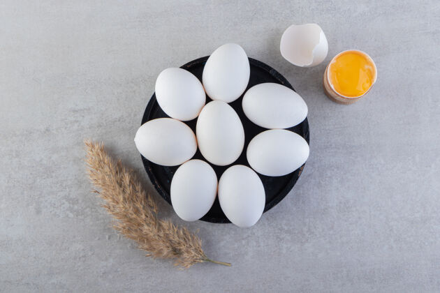 生的生的白鸡蛋 蛋黄和麦穗放在石桌上食物生的蛋清