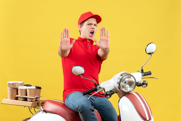 订单顶视图是一个雄心勃勃 情绪激动的年轻人 穿着红色上衣 戴着帽子 在黄色背景上展示十张订单人摩托车雄心勃勃