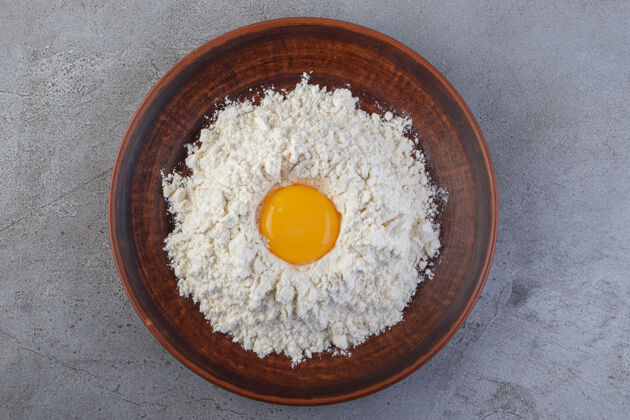 未煮熟的把新鲜的生鸡蛋放在石头上鸡蛋蛋清未经料理的