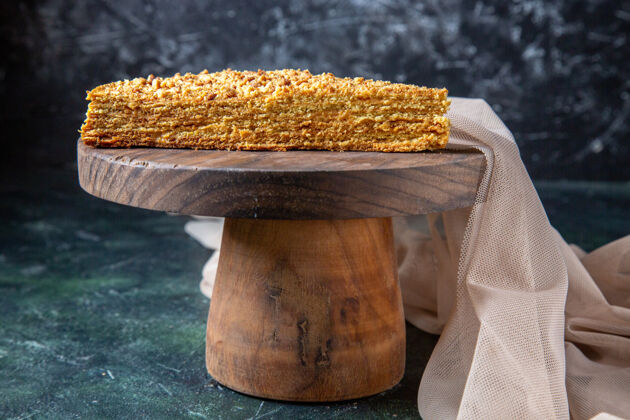 面包正面是美味的蜂蜜蛋糕片 它放在圆木板深色的表面上切片谷物食品