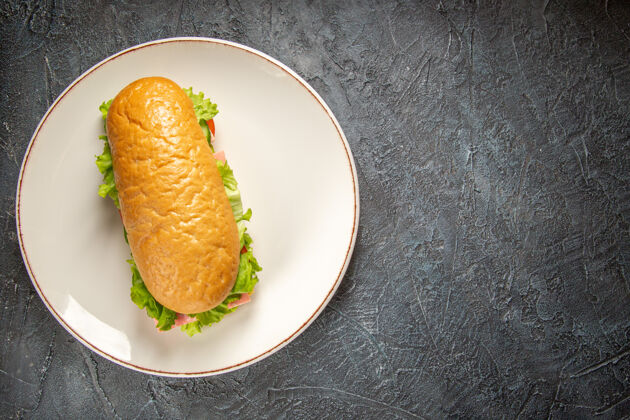 餐厅美味的自制三明治俯视图在一个白色的盘子上的右侧黑色的苦恼的表面美食苦恼小吃