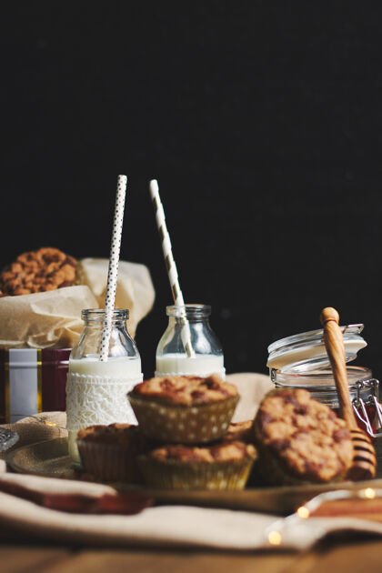 美味垂直拍摄美味的圣诞饼干松饼与蜂蜜和牛奶放在木桌上的盘子烹饪糕点特写