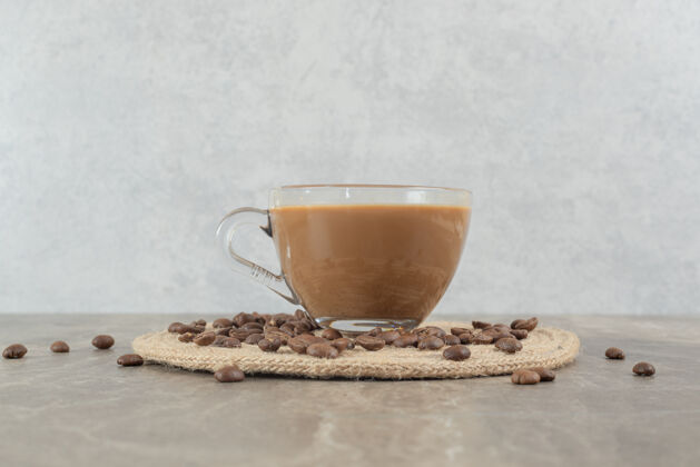 马克杯热咖啡和咖啡豆放在大理石桌上餐豆美味