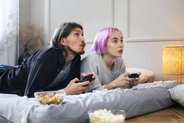 游戏在室内玩电子游戏的年轻夫妇娱乐室内乐趣