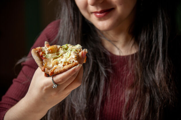 女人俯视图微笑的年轻女子吃着一片美味的比萨饼吃快餐消费者快切片
