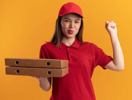 橘子一个穿着制服的漂亮送货员手里攥着拳头 手里拿着橘黄色的披萨盒送货制服披萨