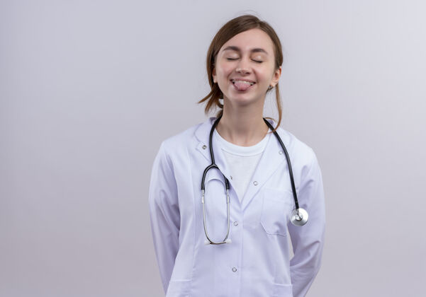 长袍俏皮的年轻女医生 穿着医用长袍 听诊器 闭着眼睛看舌头 留着复印空间表演年轻医生