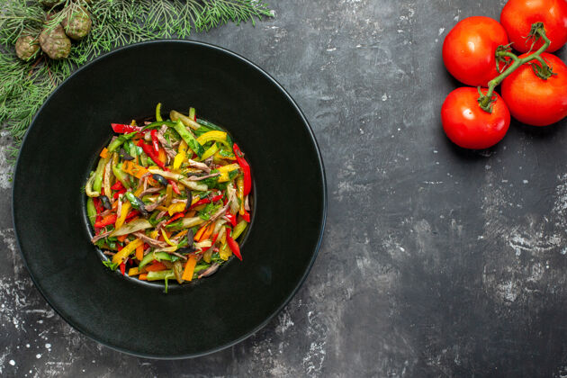 西红柿黑色表面上美味蔬菜沙拉的俯视图晚餐新鲜健康