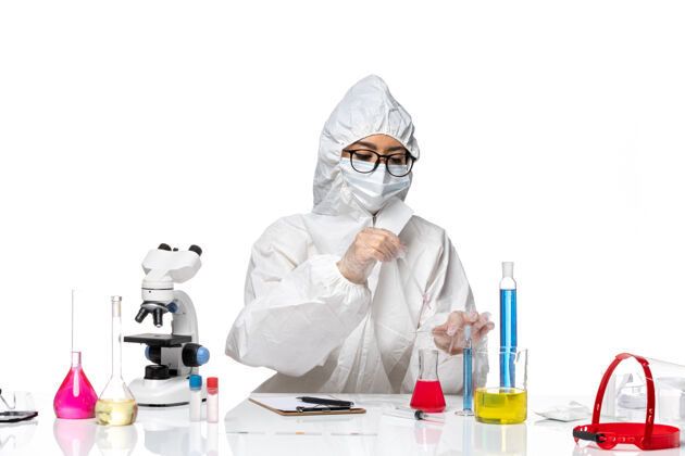 白色前视图身着特殊防护服的女化学家在浅白色背景病毒冠状病毒化学实验室工作套装视图工作