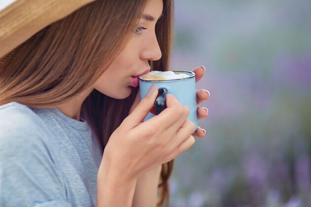 人在薰衣草地里喝咖啡的年轻女子欢呼芳香疗法自然