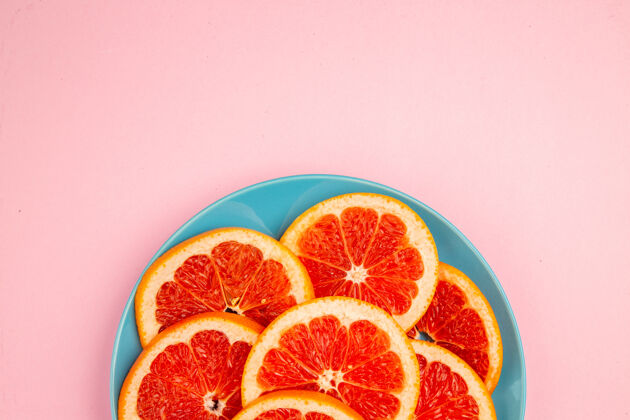 新鲜顶视图美味的葡萄柚水果片内板上的粉红色表面饮食水果葡萄柚