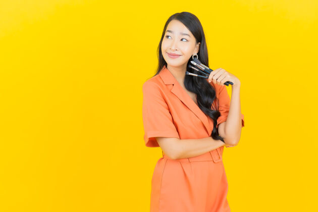 博客用黄色化妆刷描绘美丽的亚洲年轻女子女士Vlog魅力
