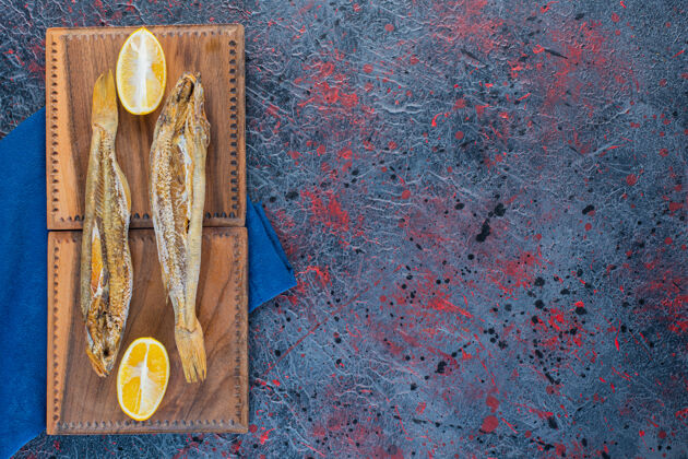 食物在木板上隔一片柠檬的咸鱼干鱼咸渔业