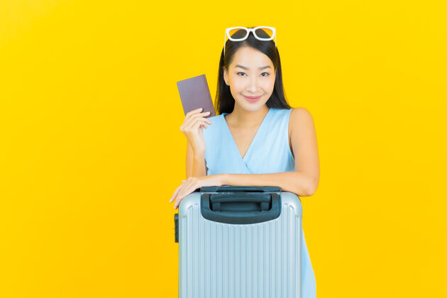 夏天肖像美丽的亚洲年轻女子带着行李包和护照准备旅行票女五颜六色