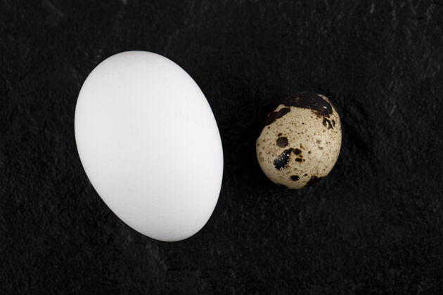 有机鸡肉和鹌鹑蛋放在黑色的表面上鸡肉鹌鹑生的
