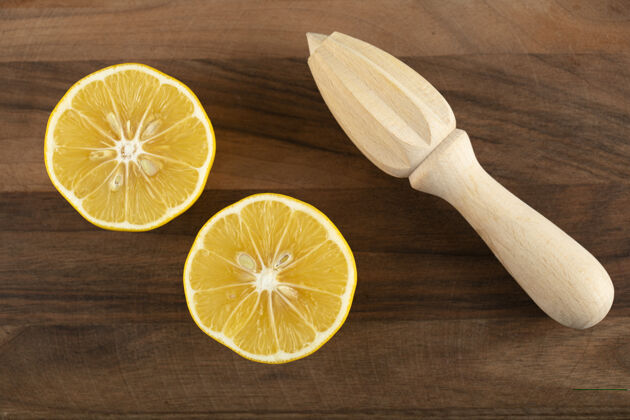 柑橘在木桌上用木铰刀把柠檬切成片木材榨汁机水果