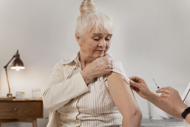 老年医生正在为一位老年妇女准备疫苗老年人内部保健