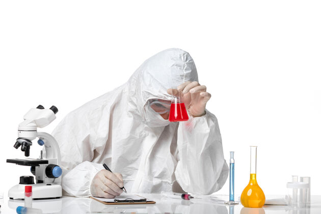 防护正面图：男医生穿着防护服 戴着面罩 因为他拿着装有红色溶液的烧瓶 在空白处写字书写大流行实验室外套
