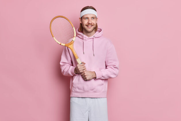 男士运动型的满脸胡须的活跃男子手持网球球拍 喜欢在业余时间玩喜爱的游戏游戏运动年轻