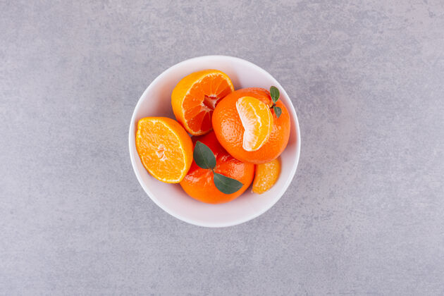 果汁整个橙色的水果 绿色的叶子放在石头表面口味水果食品