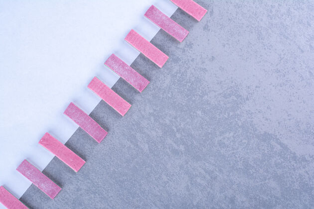 白色紫色口香糖棒对角线对齐沿边界的一张纸在大理石表面美味口香糖纸