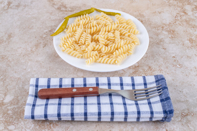 泡菜晚餐设置与通心粉和叉子毛巾大理石表面晚餐美味拼盘