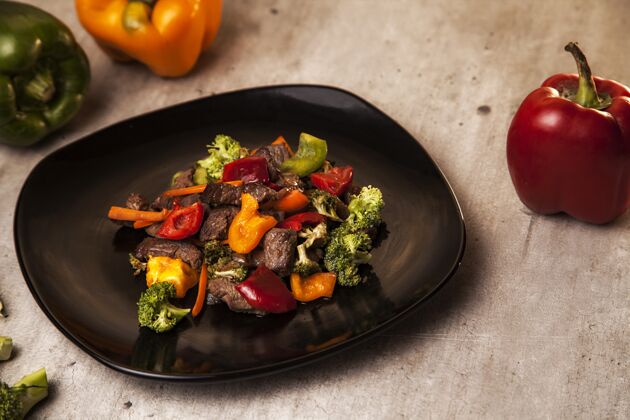 盘子特写镜头的美味和健康的一餐牛肉和烤蔬菜在一个黑色的盘子欧芹餐厅切片