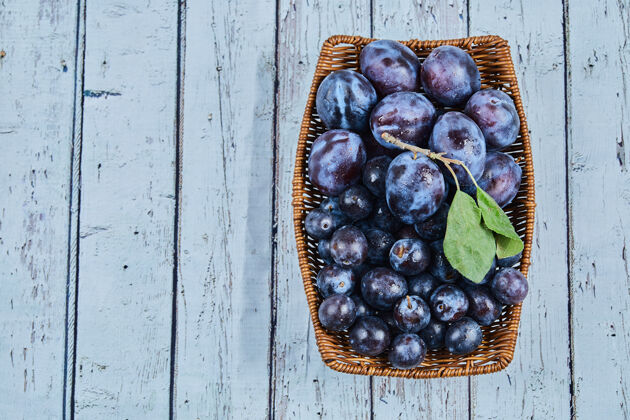 李子花园李子在一个蓝背景篮子高品质的照片浆果农业水果