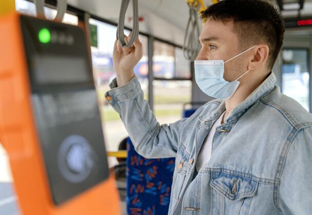乘客年轻人戴着口罩坐公交车车辆城市公共汽车外科口罩