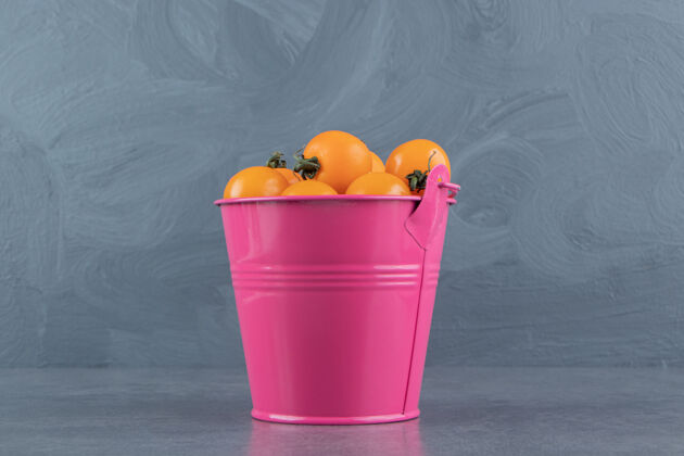健康一个粉红色的桶装满了成熟美味的黄樱桃番茄食品生的可口